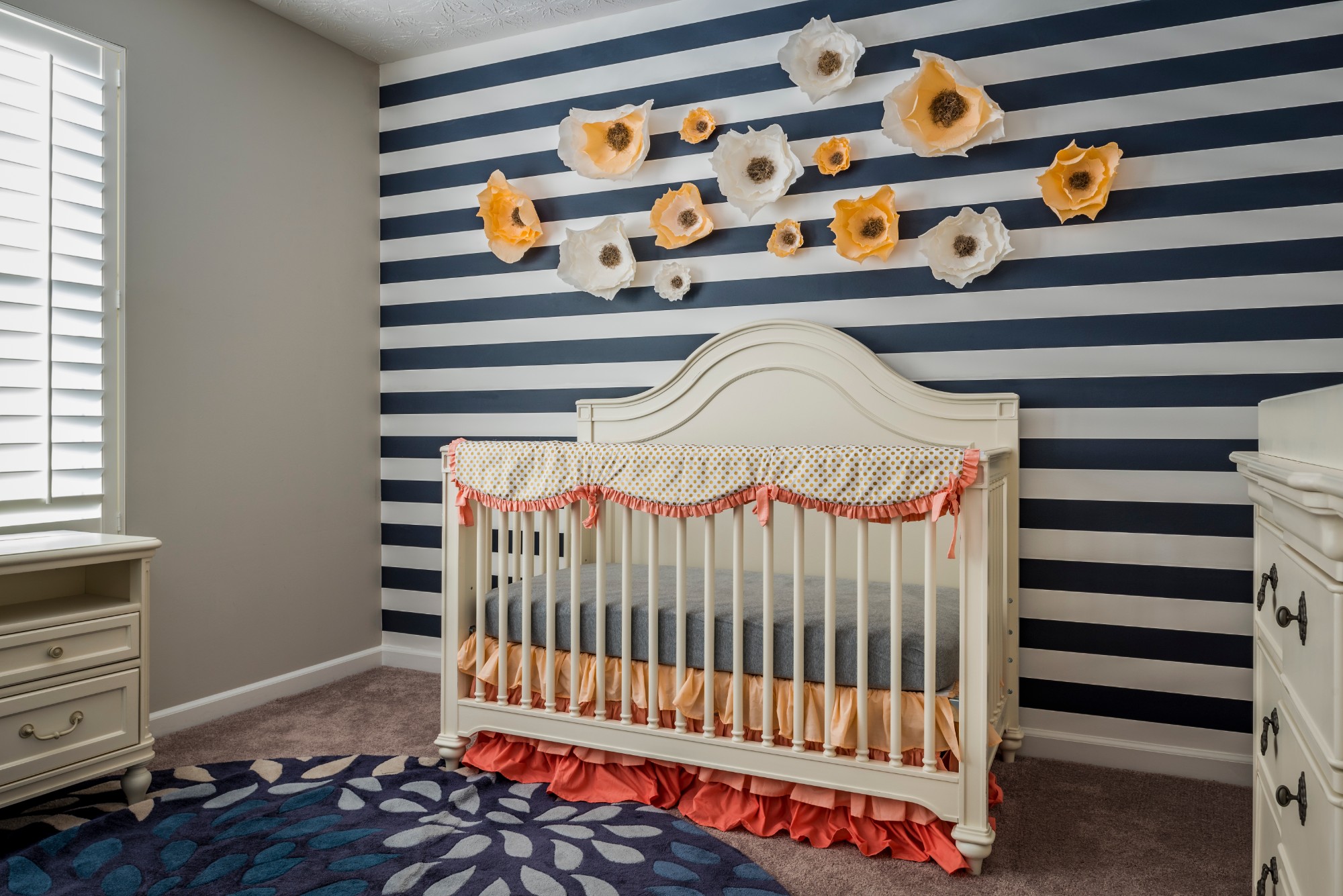 A photo of a colorful and playful nursery room with a crib and and changing table.