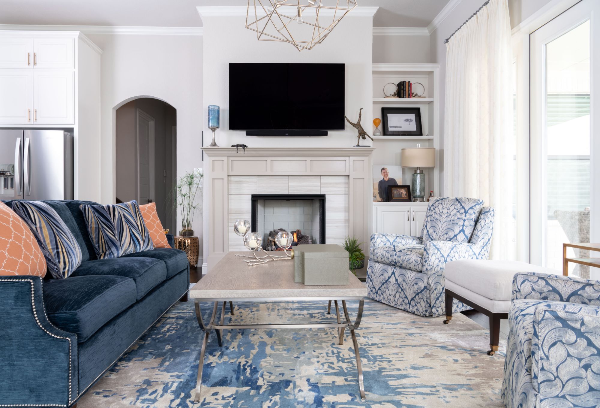 A photo of a cozy living room with a neutral color palette, featuring a comfortable sofa, two accent chairs, coffee table, and a beautiful area rug.